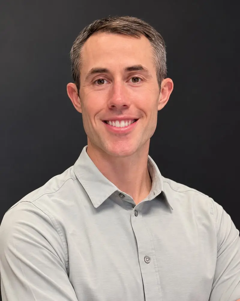 Taylor Cushman, MD, smiling, in a gray button-down shirt.